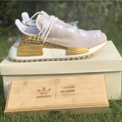 Pharrell X Adidas NMD Human Race Gold replica sneakers showcasing a vibrant gold colorway with unique design elements and premium material quality.