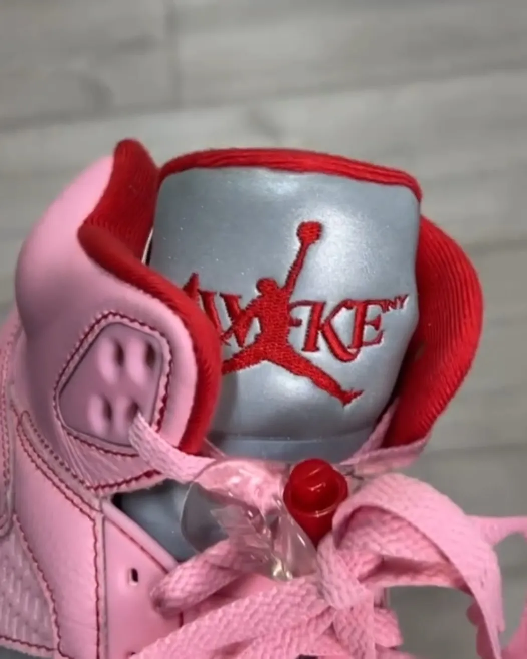 High-quality replica sneakers featuring the Awake NY Air Jordan 5 in a vibrant pink colorway, showcasing intricate detailing and stylish design elements.