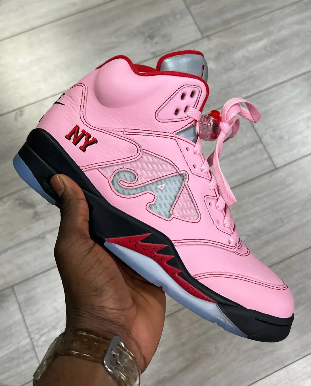 Awake NY Air Jordan 5 Pink replica sneakers displayed prominently, showcasing a unique pink colorway, high-quality craftsmanship, and stylish design elements perfect for sneaker enthusiasts.
